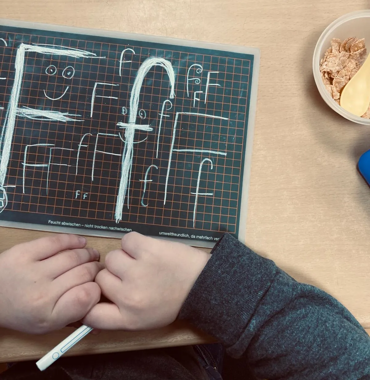 ottopankockschuledrevenack_anfangsunterricht_1 Kind übt auf Schreibtafel das Schreiben des Buchstabens F mit Kreide – erste Schreibübungen im Unterricht.