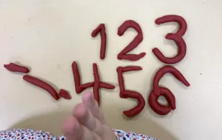 Kind formt Zahlen und Buchstaben aus Knete – spielerisches Lernen im Anfangsunterricht. Kind formt Zahlen und Buchstaben aus Knete – spielerisches Lernen im Anfangsunterricht.